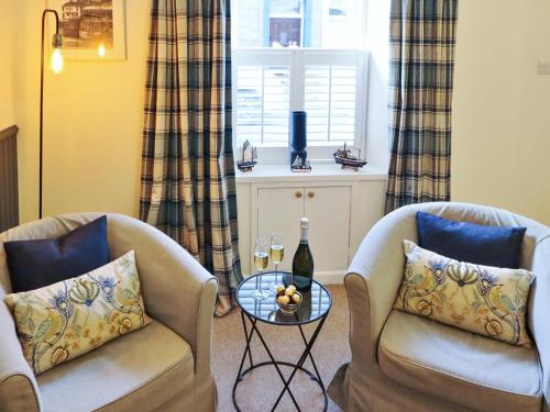 a living room with two chairs and a table at Union Street in Kirkcudbright