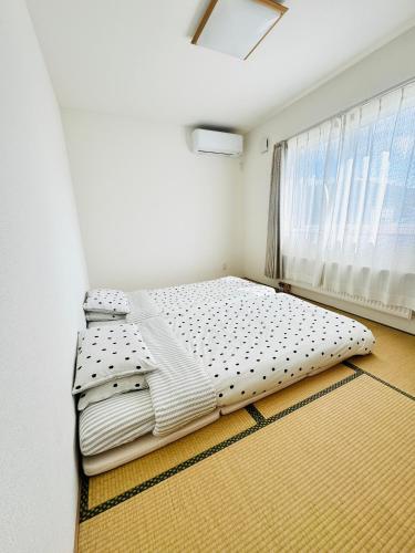 a bedroom with two beds in front of a window at Furano U Plus in Furano