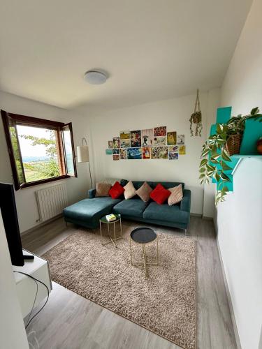 a living room with a blue couch and a rug at Appartamento Panoramico Urbino Vista Colline in Urbino