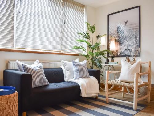 a living room with a black couch and pillows at The Rise in Scarborough