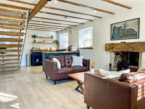 un soggiorno con divani e camino di Ivy Cottage a Falkland