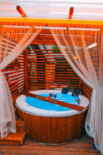 a jacuzzi tub in a room with curtains at Melodi Bungalov Sapanca in Sakarya