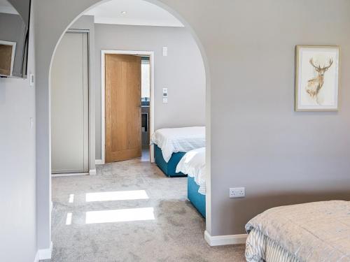 a bedroom with two beds and a hallway with two beds at Hogbert's Hideaway in Carlton Colville