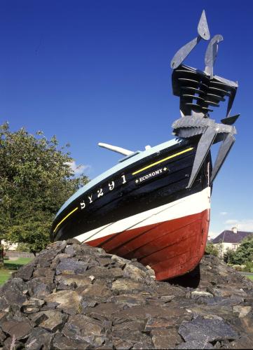 a boat sitting on top of a pile of rocks at Sandwick Bay Guest House in Stornoway