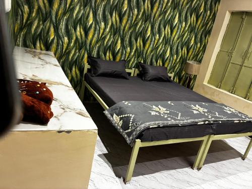 a couple of beds in a room with a wall at Prakriti wellness stay in Haridwār