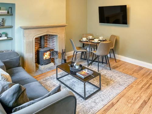 a living room with a table and a fireplace at Olive Cottage in Barnard Castle