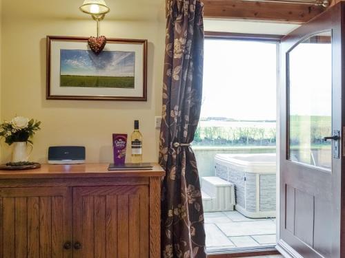 a glass door leading to a patio with a window at Little Meadow in Dearham