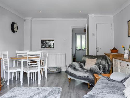 a living room with a table and chairs at Chestnut House in Wareham