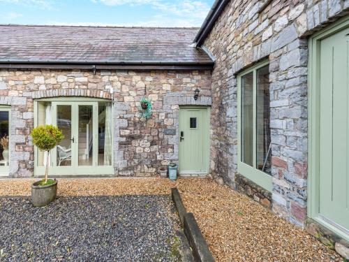 a stone house with two doors and a courtyard at Ramblers Retreat - Uk48386 in Llangadog