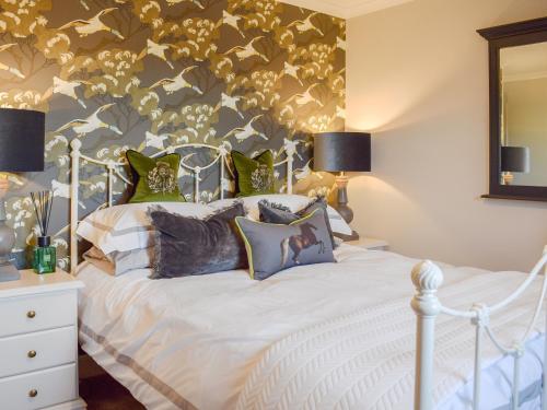 a bedroom with a white bed with pillows at The Old Stables in Howwood