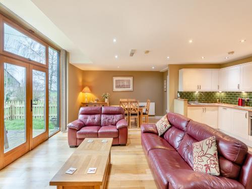 een woonkamer met een bank en een tafel bij Oak Cottage in Ware