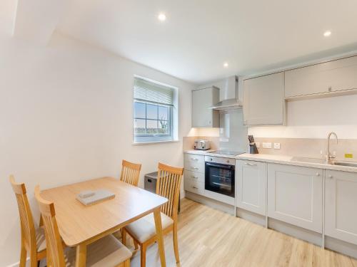 a kitchen and dining room with a table and chairs at Cartmel Cottage in Lindale