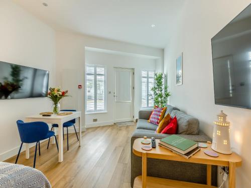 a living room with a couch and a table at Belgrave Sands Apartment in Torquay