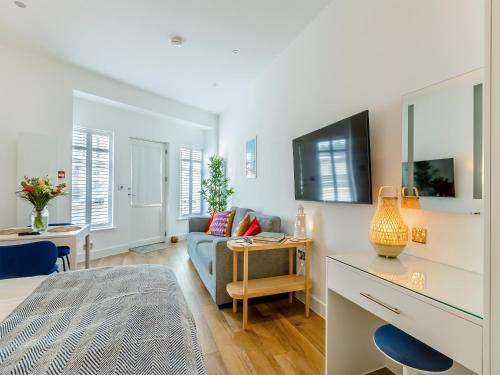 a living room with a couch and a table at Belgrave Sands Apartment in Torquay