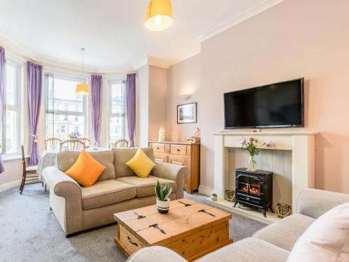 a living room with a fireplace and a tv at Buoy On The Bay in Bridlington