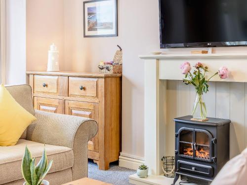 a living room with a fireplace and a tv at Buoy On The Bay in Bridlington