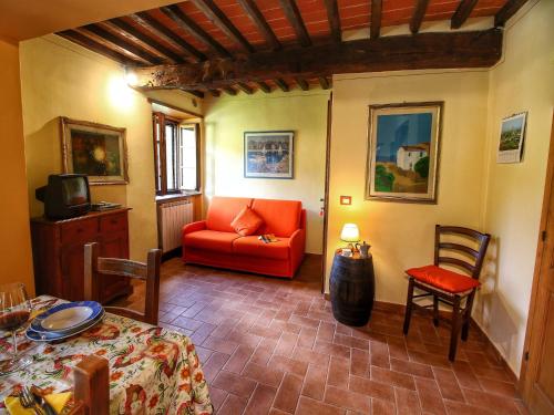 a living room with a red couch and a table at Chianti Hillside Farmhouse in Radda in Chianti