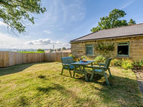 a patio with a table and chairs in a yard at Shawdon Hill Cottage in Glanton