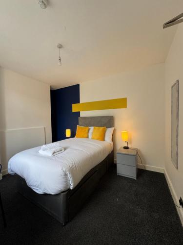 a bedroom with a large white bed with yellow pillows at 6 BR 4 Bath Central Worcester Sleeps 12 in Worcester