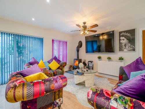 a living room with two chairs and a ceiling fan at Merriman Lodge in Glastonbury