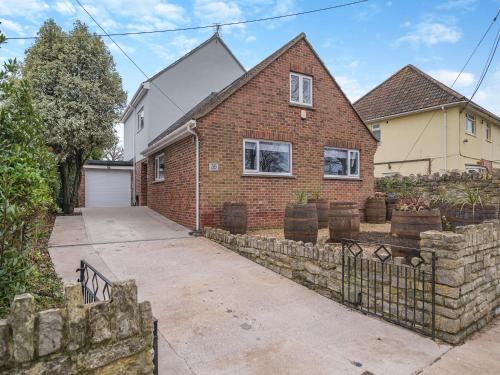 a brick house with a fence and a driveway at Merriman Lodge in Street