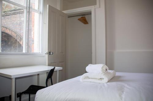 a room with a bed with towels on it at 6 BR 4 Bath Central Worcester Sleeps 12 in Worcester