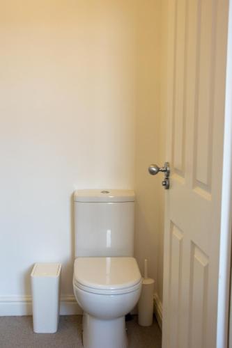 a bathroom with a white toilet and a door at 6 BR 4 Bath Central Worcester Sleeps 12 in Worcester
