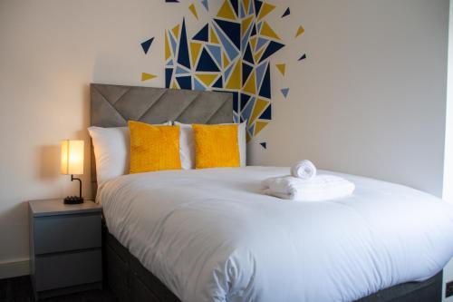 a bedroom with a large white bed with yellow pillows at 6 BR 4 Bath Central Worcester Sleeps 12 in Worcester