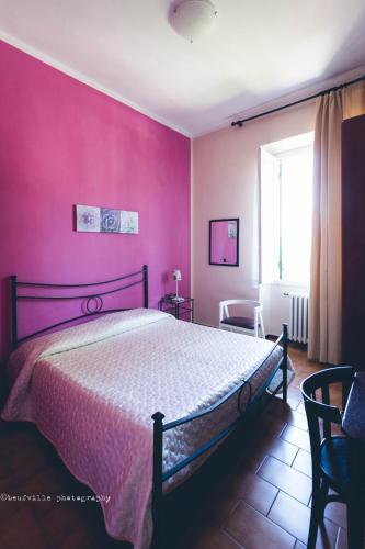 a bedroom with a bed with a pink wall at Park Hotel Salice Terme - OltrePò Pavese - in Salice Terme