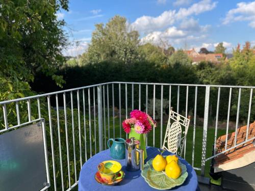 a blue table with a vase of flowers and fruit at Crown Lodge, Great Glemham in Saxmundham