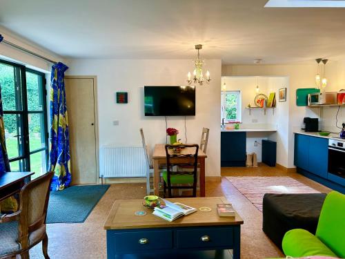 a living room with a couch and a table at Crown Lodge, Great Glemham in Saxmundham