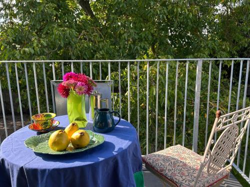 a blue table with fruit and a vase of flowers at Crown Lodge, Great Glemham in Saxmundham