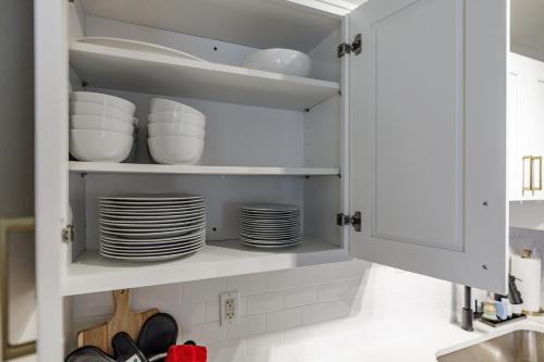 a kitchen cabinet with plates and dishes in it at Classic City Quarters in Athens