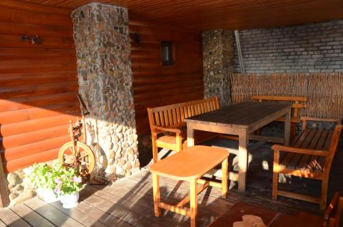 una mesa de madera y sillas en el porche de una cabaña en Agrousadba Kamenetskoye Zatishye, en Kamenets