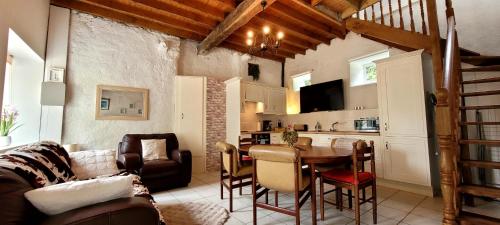 a living room with a table and a kitchen at Maison de caractère - L'évasion forestière in Baguer-Pican