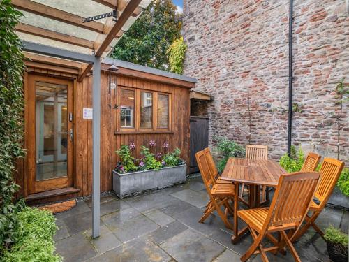a patio with a wooden table and chairs at Rock House in Wells