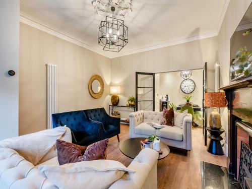 a living room with white furniture and a chandelier at Old Bank House in Barnard Castle