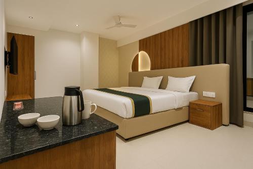 a hotel room with a bed and a kitchen with a counter at Hotel Veronica in Indore