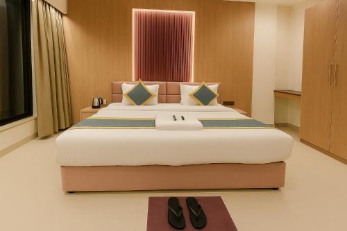a bedroom with a large bed with a pair of shoes at Hotel Veronica in Indore