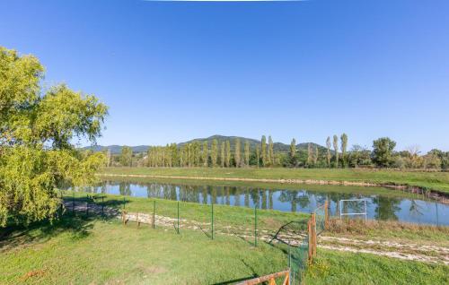 a field with a fence next to a river at Gorgeous Apartment In Montone in Montone