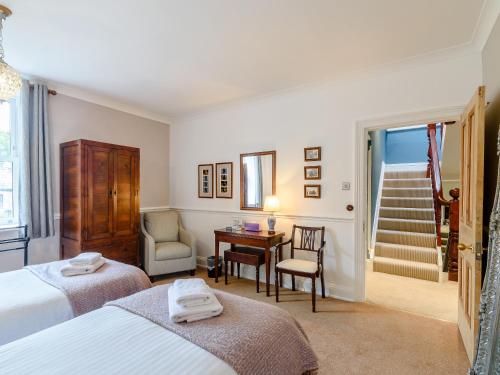 a bedroom with two beds and a desk and a staircase at Temple House in West Burton