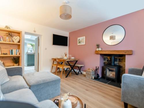 a living room with a couch and a fireplace at Percy's Cottage in Castleton