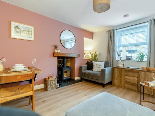 a living room with a chair and a mirror at Percy's Cottage in Castleton