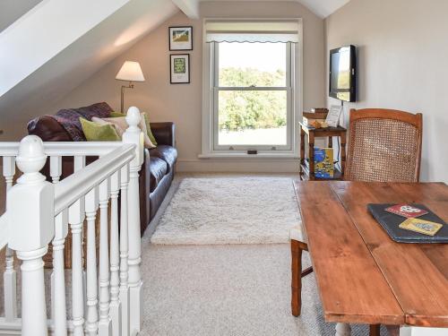 a living room with a couch and a table at Cartws Blaenparc Coach House - Uk41031 in Mydroilin