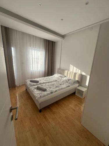a bedroom with a bed and a sliding door at City Center Apartment in Zrenjanin