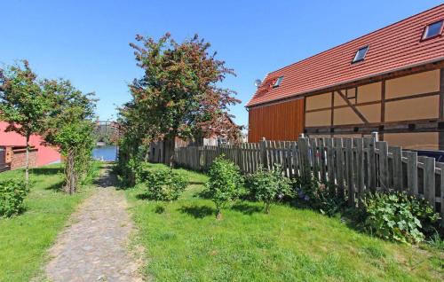 a fence next to a house and a yard at Ferienwohnung Malchow in Malchow