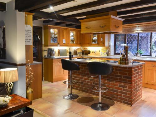 a kitchen with a brick island with two stools at Lambourne House - Ukc2831 in Winthorpe