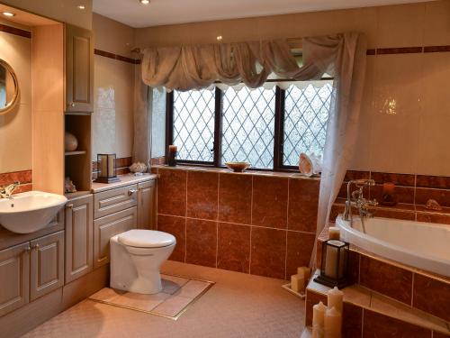 a bathroom with a toilet and a tub and a sink at Lambourne House - Ukc2831 in Winthorpe