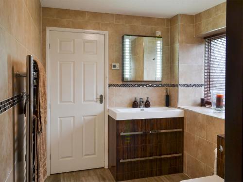 a bathroom with a white sink and a mirror at Lambourne House - Ukc2831 in Winthorpe