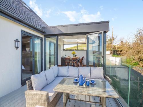 a patio with a couch and a table on a deck at Blodfryn in Llandudno Junction